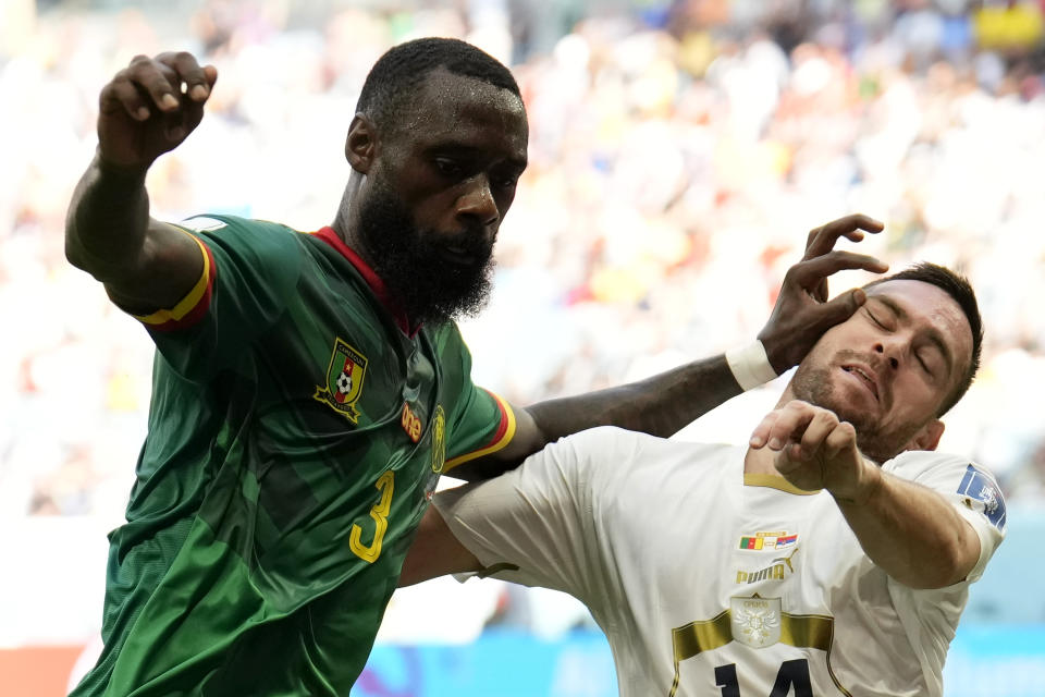 Cameroon's Nicolas Nkoulou, left, fights for the ball with Serbia's Andrija Zivkovic during the World Cup group G soccer match between Cameroon and Serbia, at the Al Janoub Stadium in Al Wakrah, Qatar, Monday, Nov. 28, 2022. (AP Photo/Francisco Seco)