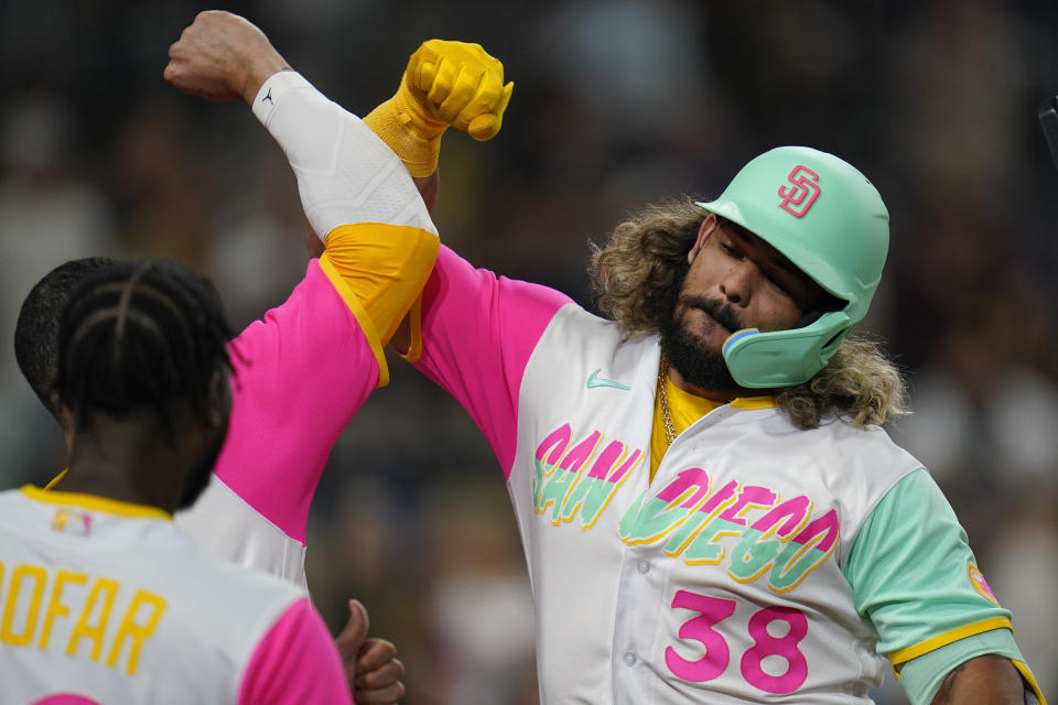 San Diego Padres' Jorge Alfaro, right, celebrates with teammates after hitting a three-run home run during the fifth inning of a baseball game against the Minnesota Twins, Friday, July 29, 2022, in San Diego. (AP Photo/Gregory Bull)