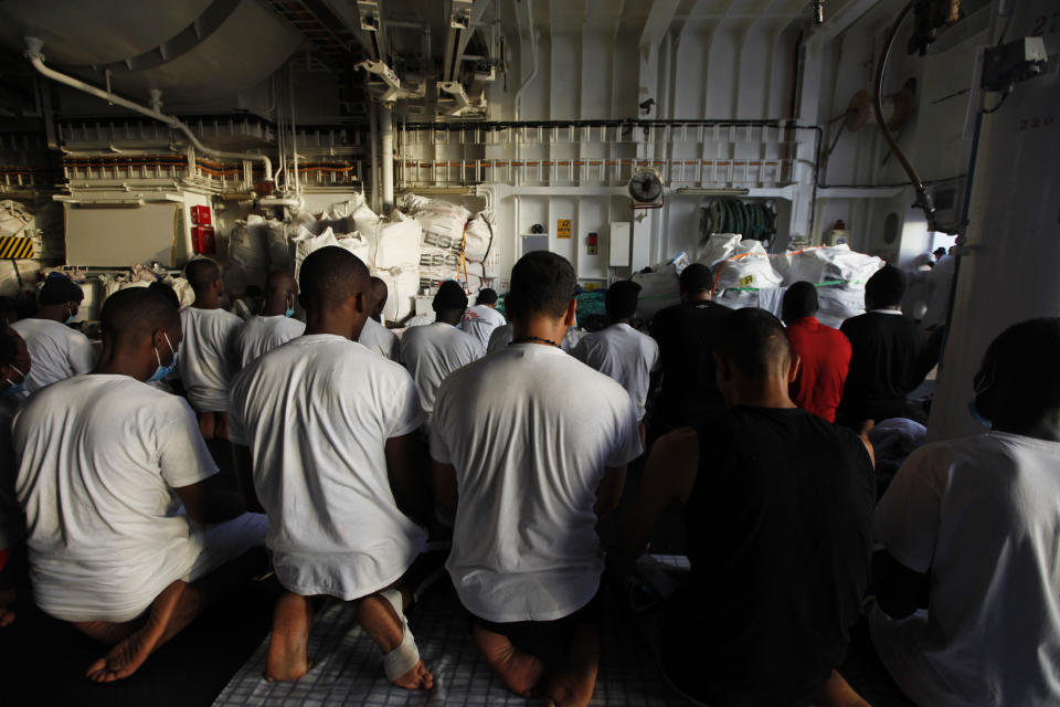 Migrants pray on the deck of the Geo Barents, a rescue vessel operated by MSF (Doctors Without Borders) off Libya, in the central Mediterranean route, Wednesday, Sept. 22, 2021. (AP Photo/Ahmed Hatem)