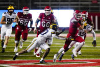 Rutgers' Noah Vedral (0) rushes past Michigan's Brad Hawkins, left, and Josh Ross, right, during the first half of an NCAA college football game Saturday, Nov. 21, 2020, in Piscataway, N.J. (AP Photo/Frank Franklin II)