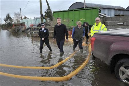 Britain's Prime Minister David Cameron (2nd L) with Bridgwater and West Somerset MP Ian Liddell-Grainger (3rd L) during a visit to flood affected areas at Goodings Farm in Fordgate, Somerset February 7, 2014. REUTERS/Tim Ireland/Pool