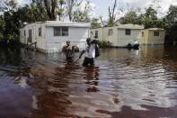 <p>Angelina Ventura, left, and Jose Gonzalez retrieve belongings from their flooded home in the wake of Hurricane Irma in Bonita Springs, Fla., Sept. 12, 2017. (AP Photo/David Goldman) </p>