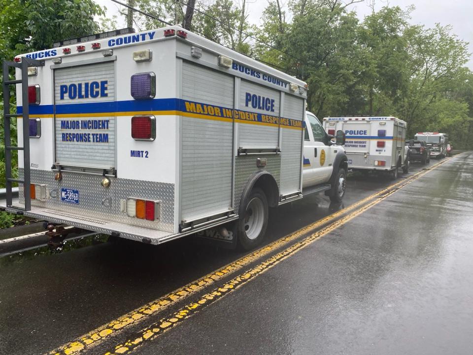 Bucks County Major Incident Response Team vehicles are parked along Taylorsville Road in Upper Makefield on Sunday July 16, 2023, as crews continue to comb the area hit by flooding