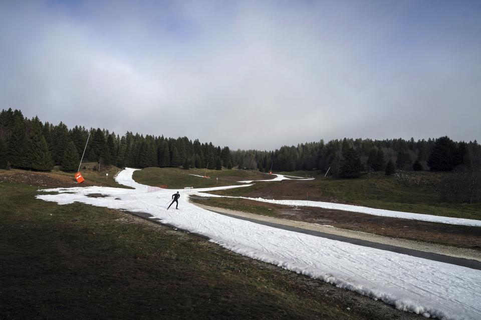 FILE - A man practices Nordic skiing despite the lack of snow in La Feclaz, near Chambery, on Jan. 5, 2023, in the French Alps. (AP Photo/Laurent Cipriani, File)