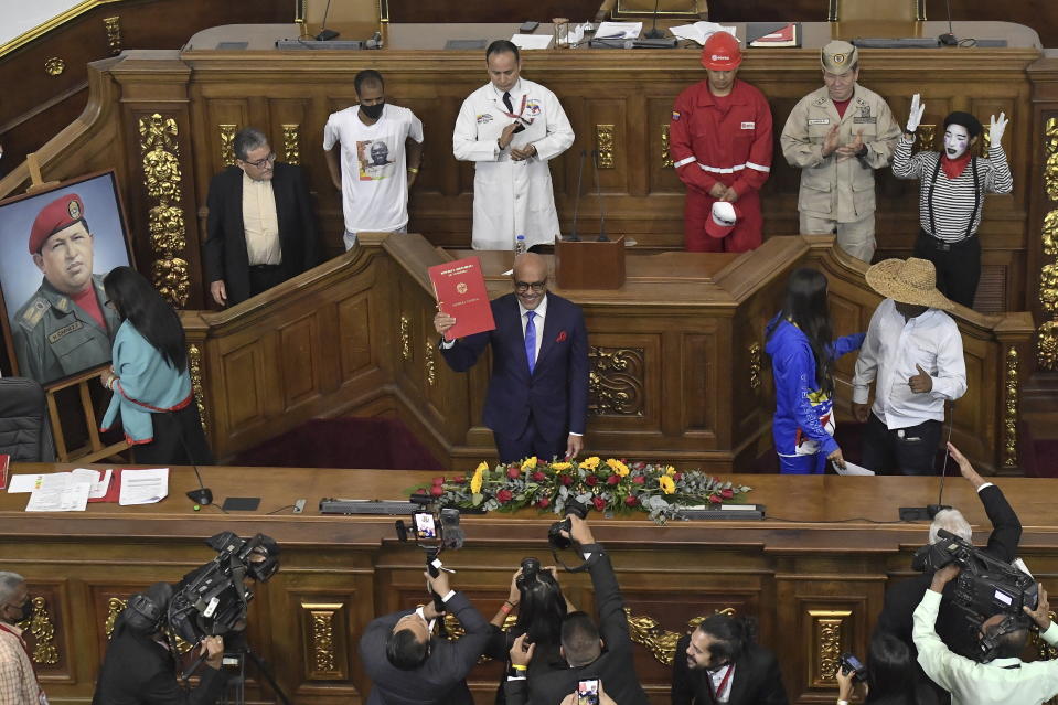 National Assembly President Jorge Rodriguez a legislative rules book after being sworn-in as the body's leader for another term in Caracas, Venezuela, Thursday, Jan. 5, 2023. (AP Photo/Matias Delacroix)