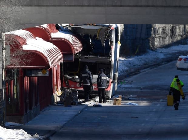 Transport Canada officials look at the scene where double-decker 8155 struck a transit shelter at Westboro Station in Ottawa in January 2019. (Justin Tang/Canadian Press - image credit)