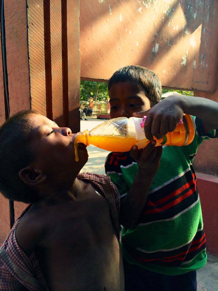 田定豐攝影作品之一，把果汁分給弟弟的印度小童。（混種時代提供）