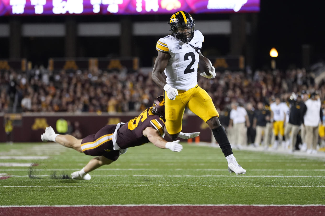 Iowa running back Kaleb Johnson (2) runs for a 40-yard rushing touchdown as Minnesota defensive back Coleman Bryson, left, tries to tackle him during the second half of an NCAA college football game, Saturday, Sept. 21, 2024, in Minneapolis. (AP Photo/Abbie Parr)