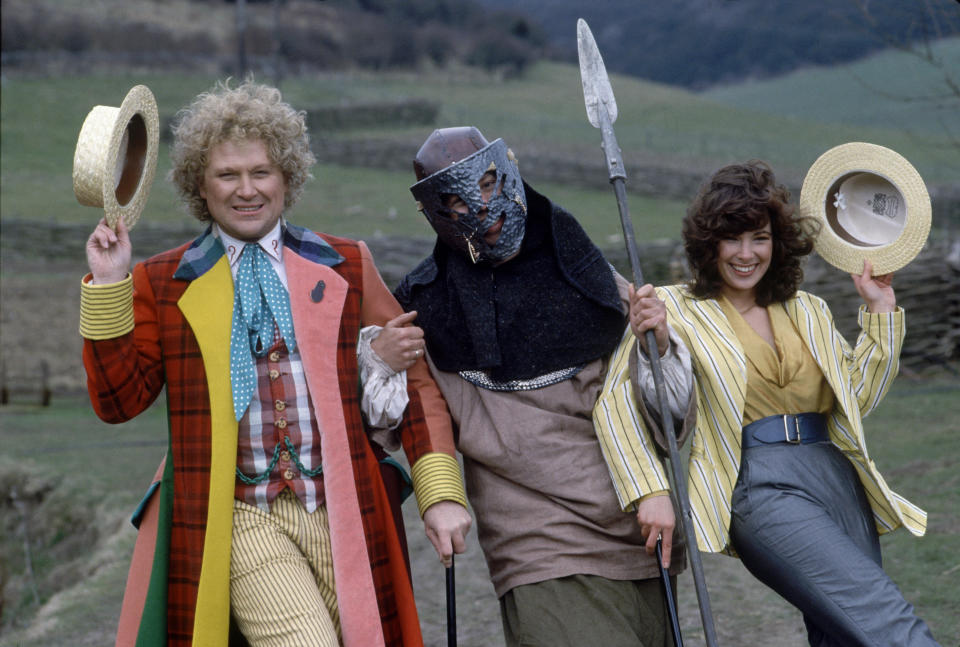 Colin Baker wearing his colourful Doctor Who costume links arms with a viking-type character and Nicola Bryant (right) in a publicity still for Doctor Who. (PA/Alamy)