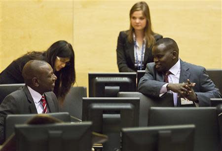 Kenya's Deputy President William Ruto speaks with broadcaster Joshua arap Sang (R) in the courtroom before their trial at the International Criminal Court (ICC) in The Hague September 10, 2013. REUTERS/Michael Kooren