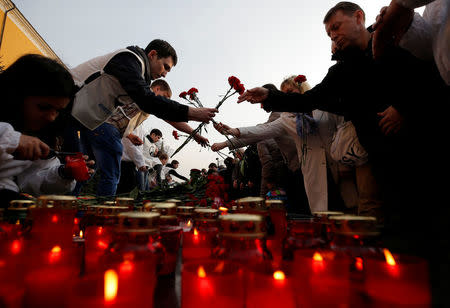 People lay flowers during a memorial to pay tribute to the victims of the St. Petersburg metro blast that took place on April 3, in central Moscow, Russia April 6, 2017. REUTERS/Maxim Shemetov