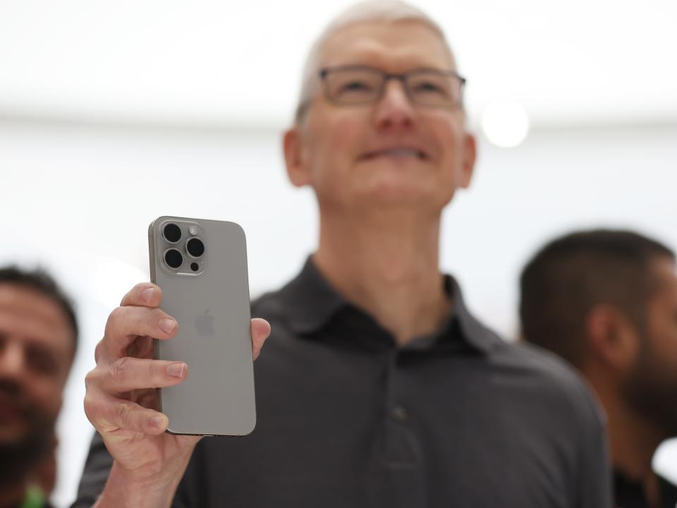 Tim Cook holding up the iphone 15