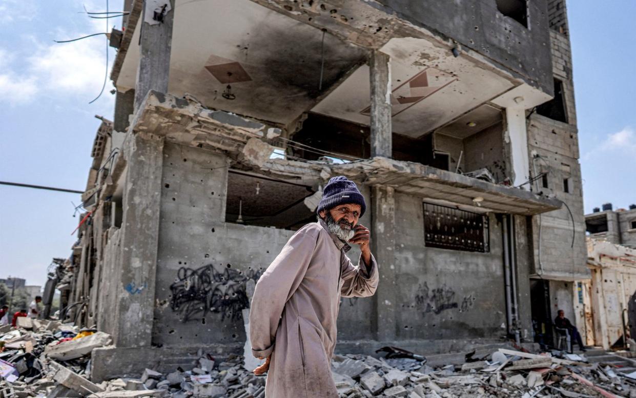 A man walks through rubble by a heavily damaged building in the eastern side of the Maghazi camp