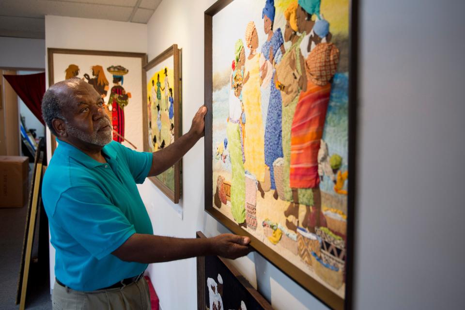 Nathaniel Harris, owner of Woodcuts Gallery and Framing, adjusts a piece by artist Ludie Amos in a file photo from Thursday, Aug. 18, 2016. Harris died in February 2024, more than 35 years after he first opened his Jefferson Street business.