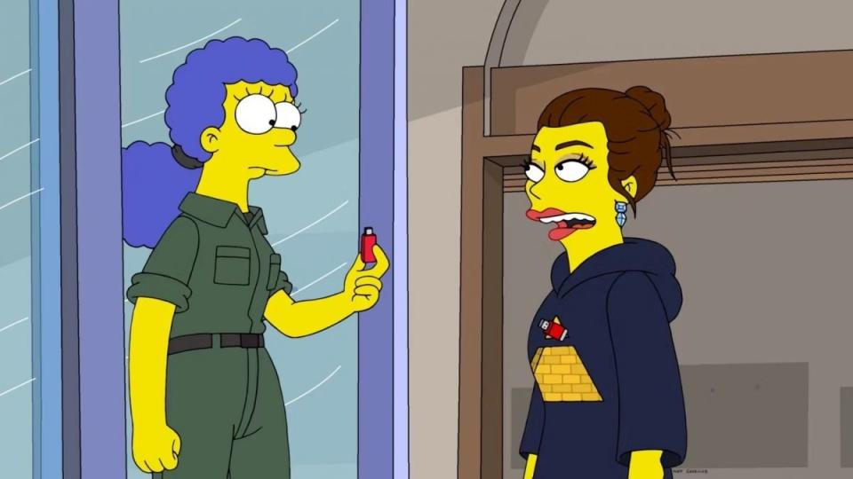 Marge holds a red usb to a woman in a weird robe on The Simpsons: Treehouse of Horror XXXIV