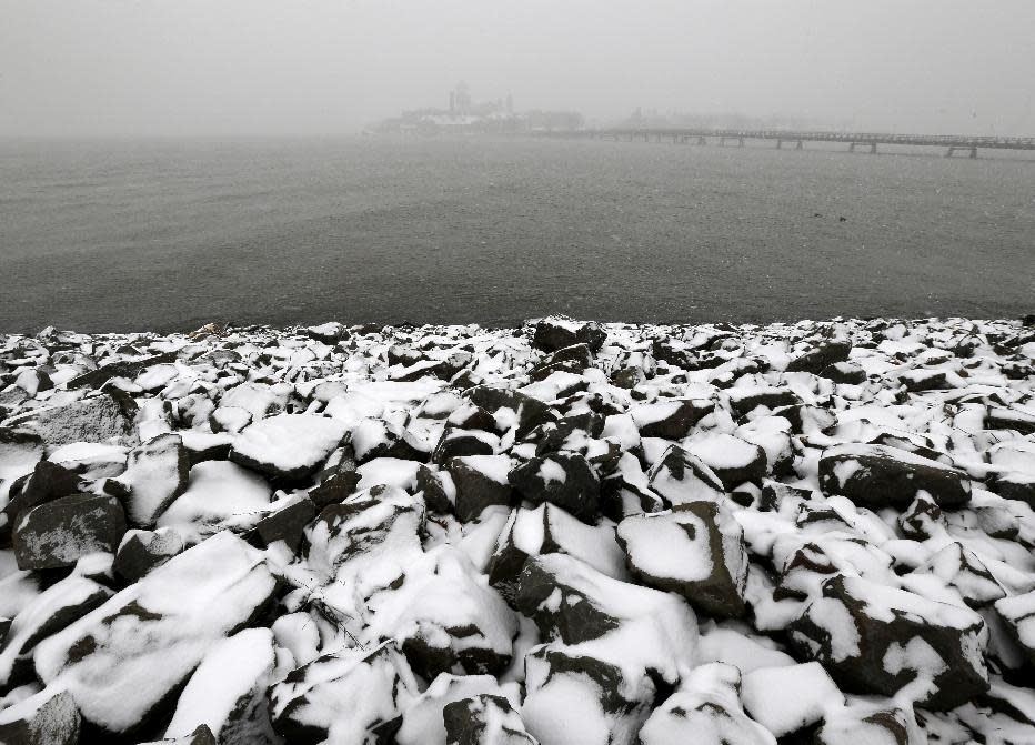 Sideways snow cuts the visibility of Ellis Island, top, seen from Liberty State Park, as a storm moves into the region, Tuesday, Jan. 21, 2014, in Jersey City, N.J. Ellis Island was set tho host New Jersey Gov. Chris Christie's inauguration party, but hazardous conditions are expected, forcing the party to be canceled. Celebrations to mark the start of Christie's second term could be tempered by investigations into traffic tie-ups that appear to have been ordered by his staff for political retribution and an allegation that his administration linked Superstorm Sandy aid to approval for a real estate project. (AP Photo/Julio Cortez)