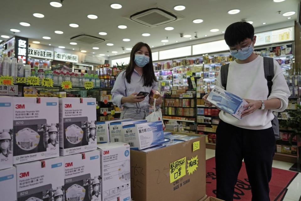 Customers purchase protective face masks at a pharmacy in Hong Kong.