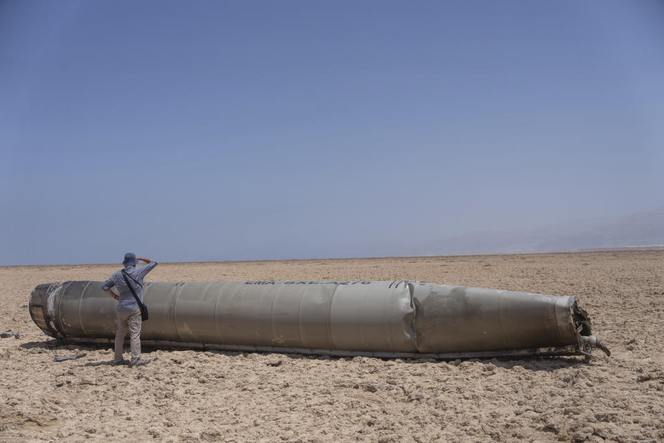 A photojournalist looks at a part of a ballistic missile that fell near the Dead Sea in Israel, April 21, 2024. The missile’s origin and how it got there wasn’t immediately clear. (AP Photo/Ohad Zwigenberg)