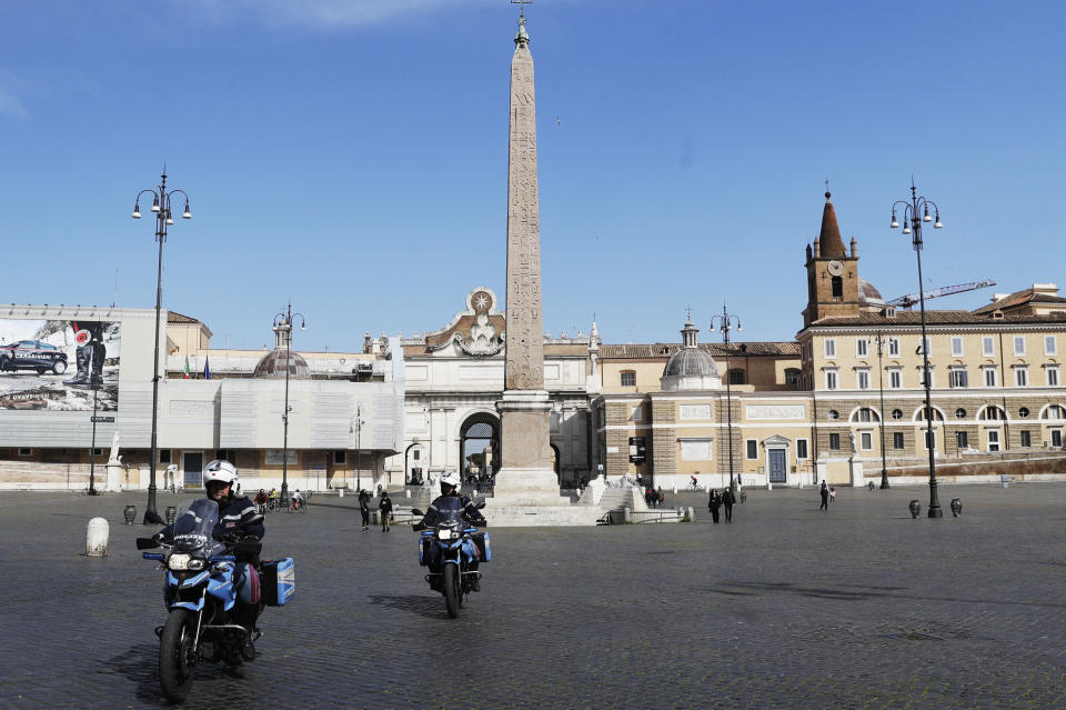 Police officers patrol Rome's central Piazza del Popolo, Saturday, April 3, 2021. Italy went into lockdown on Easter weekend in its effort to battle then Covid-19 pandemic. (AP Photo/Gregorio Borgia)