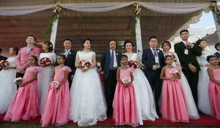 Couples pose for photographs during a mass wedding ceremony for fifty Chinese pairs in Colombo, Sri Lanka, December 17, 2017. REUTERS/Dinuka Liyanawatte