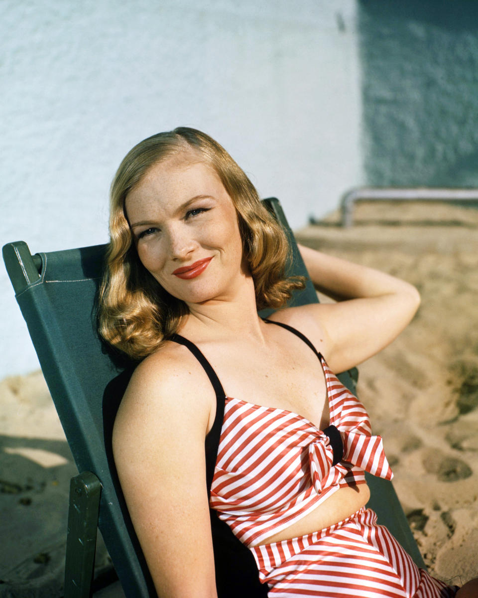 Lounging by the pool in a red-and-white striped swimsuit, around 1945.