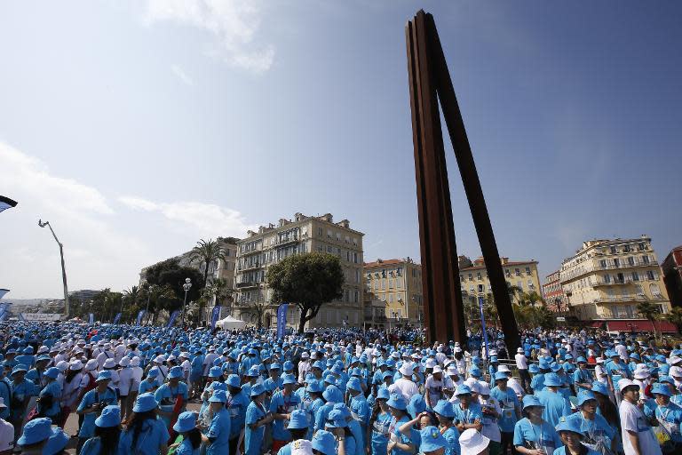 Employees of Chinese company Tiens attend a parade on May 8, 2015 in Nice, France, organized by the company's CEO Li Jinyuan