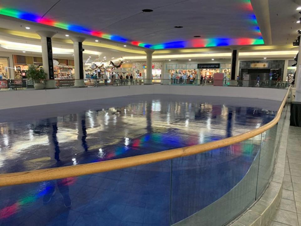 The skating surface in inset from Eastdale Mall's floor. There's a glass rall around it, with a wooden rail that people can lean on as they watch skaters.