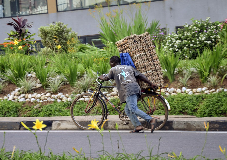 In this photo taken Thursday, March 26, 2020 a man transports cartons of eggs on the back of a bicycle due to restrictions on movement attempting to halt the spread of the new coronavirus, in Kigali, Rwanda. The new coronavirus causes mild or moderate symptoms for most people, but for some, especially older adults and people with existing health problems, it can cause more severe illness or death. (AP Photo)