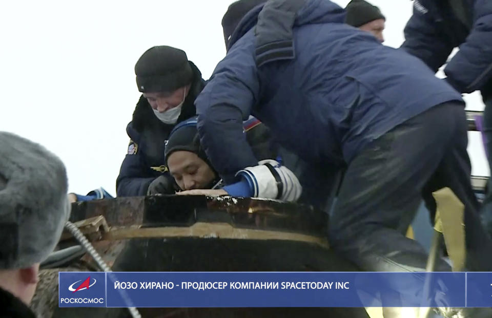 In this photo taken from video footage released by the Roscosmos Space Agency, Russian space agency rescue team help spaceflight participant Yozo Hirano to get from the capsule shortly after the landing of the Russian Soyuz MS-20 space capsule about 150 km ( 80 miles) south-east of the Kazakh town of Zhezkazgan, Kazakhstan, Monday, Dec. 20, 2021. A Japanese billionaire, his producer and a Russian cosmonaut safely returned to Earth on Monday after spending 12 days on the International Space Station. (Roscosmos Space Agency via AP)