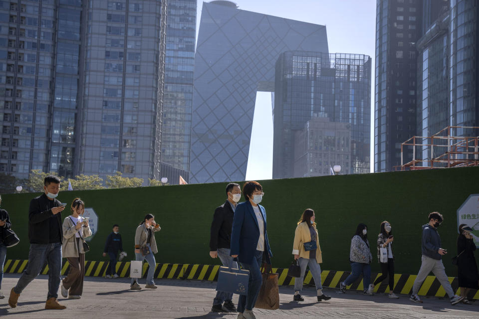 FILE - Commuters walk along a path in the central business district during the morning rush hour in Beijing, on April 18, 2023. Foreign companies are shifting investments and their Asian headquarters out of China as confidence plunges following the expansion of an anti-spying law and other challenges, a business group said Wednesday, June 21, 2023. (AP Photo/Mark Schiefelbein, File)