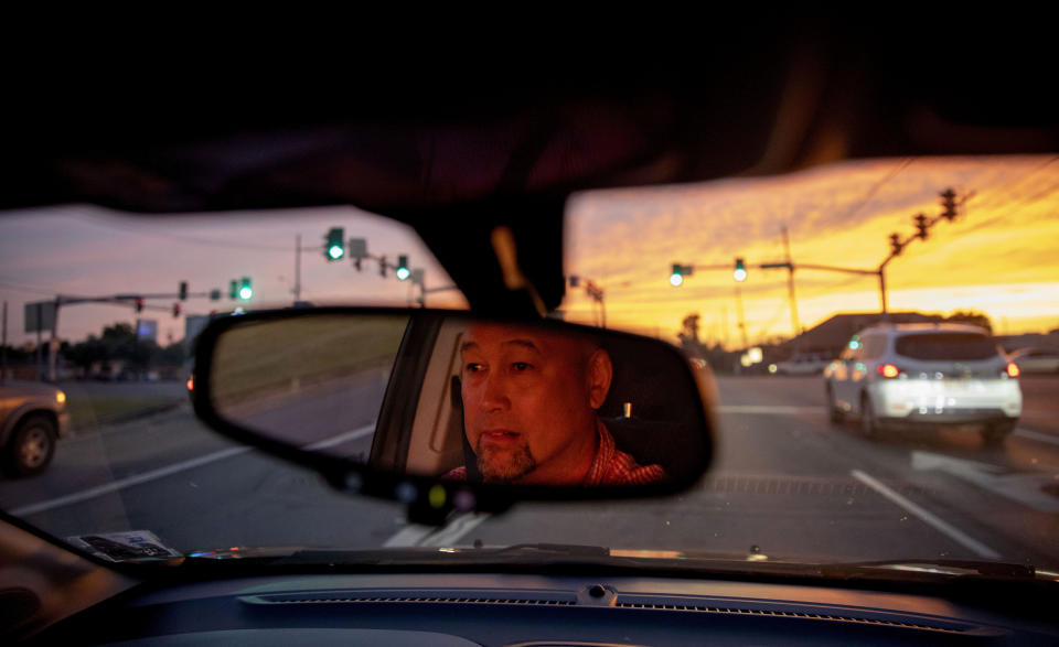 Robby Perez, who says in a lawsuit he was sexually abused by a priest when he was 11 years old in Guam, sits at a traffic light during sunset in New Orleans, where he now lives, Wednesday, June 12, 2019. Perez says he endured five years of sexual abuse, never telling anyone. Toward the end, he says, he fell in love with the priest, David Anderson. But when he professed his feelings, Anderson ended their relationship, saying he had to put God first. When reached by the AP, Anderson said, "I was young, the person was young... It's a long, long time ago." (AP Photo/David Goldman)