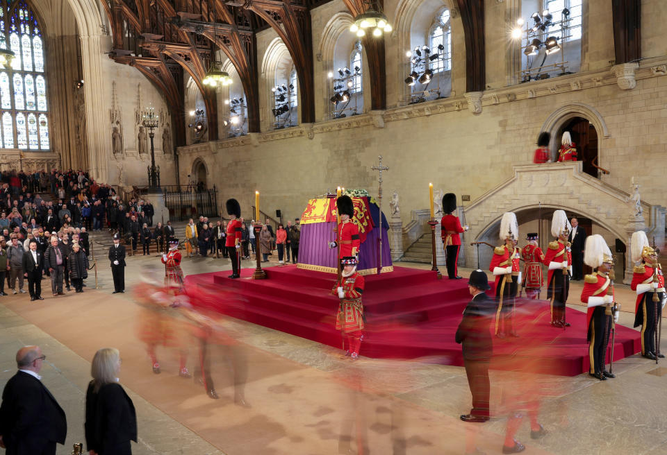 The King's Bodyguards, formed of Gentlemen at Arms, Yeomen of the Guard and Scots Guards, change guard duties around the coffin of Queen Elizabeth II during its lying in State inside Westminster Hall, at the Palace of Westminster in London, Sunday, Sept. 18, 2022. (Adrian Dennis/Pool Photos via AP)