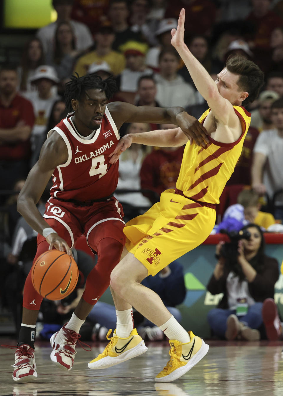 Oklahoma guard Joe Bamisile (4) pushes Iowa State guard Caleb Grill (2) out of his way as he tries to drive the ball during the first half of an NCAA college basketball game, Saturday, Feb. 25, 2023, in Ames, Iowa. (AP Photo/Justin Hayworth)