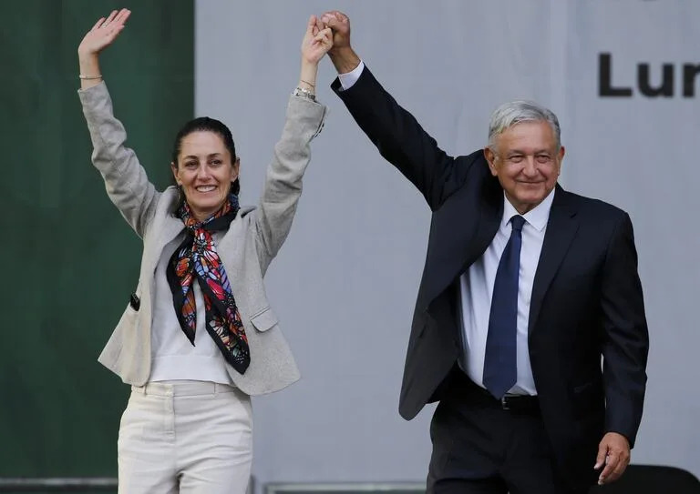 El presidente mexicano Andrés Manuel López Obrador, a la derecha, y la alcaldesa de Ciudad de México, Claudia Sheinbaum, saludan a simpatizantes tras un mitin para celebrar el primer aniversario de su elección en el Zócalo de Ciudad de México, el 1 de julio de 2019.