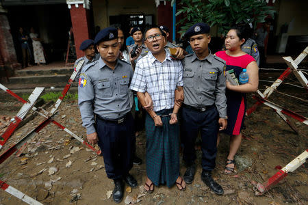 Detained Reuters journalist Wa Lone is escorted by police officers at Insein court in Yangon, Myanmar July 16, 2018. REUTERS/Ann Wang