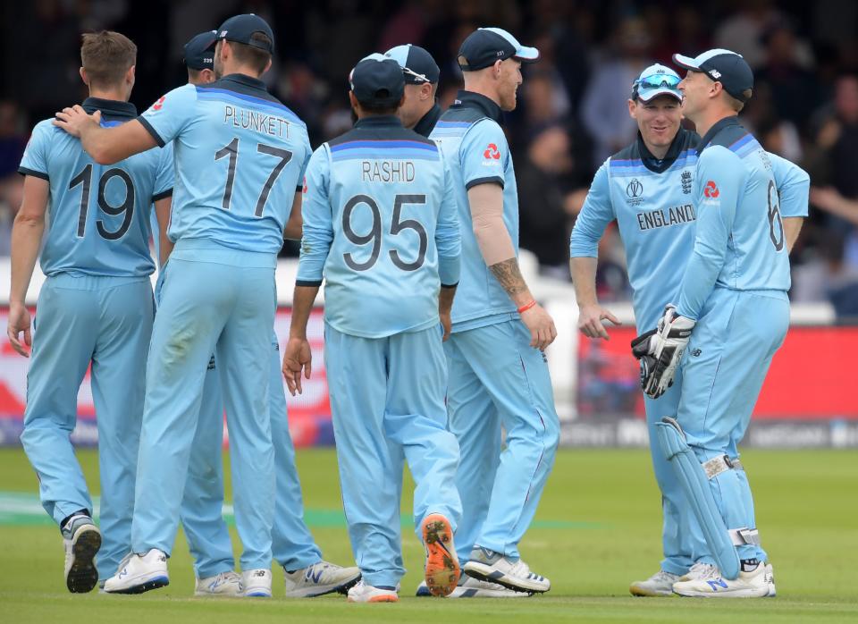 Morgan celebrates with teammates after the dismissal of New Zealand's set batsman Tom Latham (Photo by Dibyangshu Sarkar / AFP)