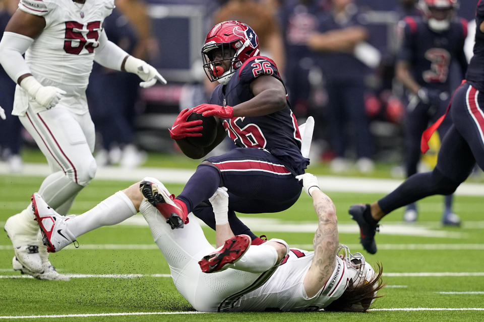 Houston Texans running back Devin Singletary (26) runs the ball for a first down before being tackled by Arizona Cardinals linebacker Dennis Gardeck in the first half of an NFL football game in Houston, Sunday, Nov. 19, 2023. (AP Photo/David J. Phillip)