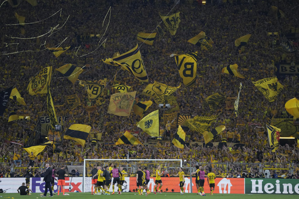 Dortmund supporters wave flags after the Champions League semifinal first leg soccer match between Borussia Dortmund and Paris Saint-Germain at the Signal-Iduna Park stadium in Dortmund, Germany, Wednesday, May 1, 2024. (AP Photo/Matthias Schrader)