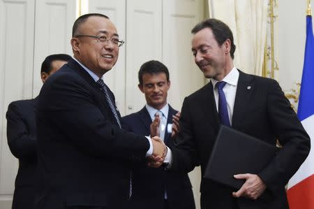 Fabrice Bregier (R), President and CEO of Airbus, shakes hands with Li Hai (L), President and CEO of China Aviation Supplies Holding Company (CAS), during an agreement signing ceremony as French Prime minister Manuel Valls (2ndR) and Chinese Premier Li Keqiang look on at the Hotel Matignon in Paris, France, June 30, 2015. REUTERS/Dominique Faget/Pool