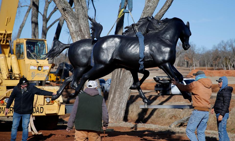 Workers on Jan. 11 install the "Valle del Caballo," bronze statue by sculptor by Paul Moore in Edmond.