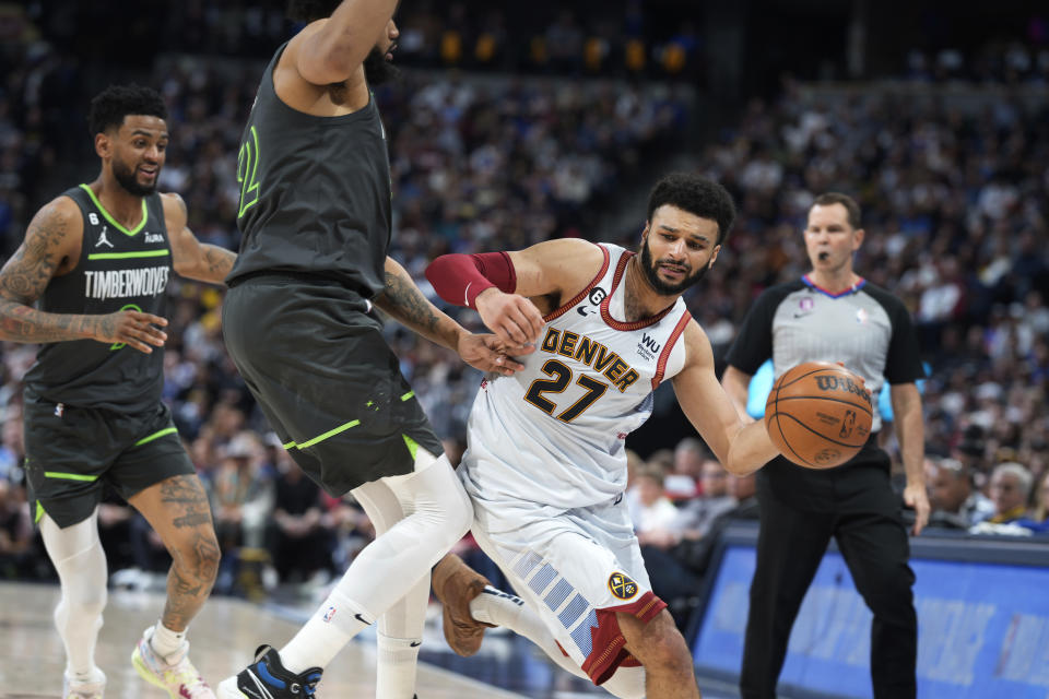 Denver Nuggets guard Jamal Murray, right, works against Minnesota Timberwolves center Karl-Anthony Towns, center, as guard Nickeil Alexander-Walker watches during the second half of Game 5 of an NBA basketball first-round playoff series Tuesday, April 25, 2023, in Denver. (AP Photo/David Zalubowski)