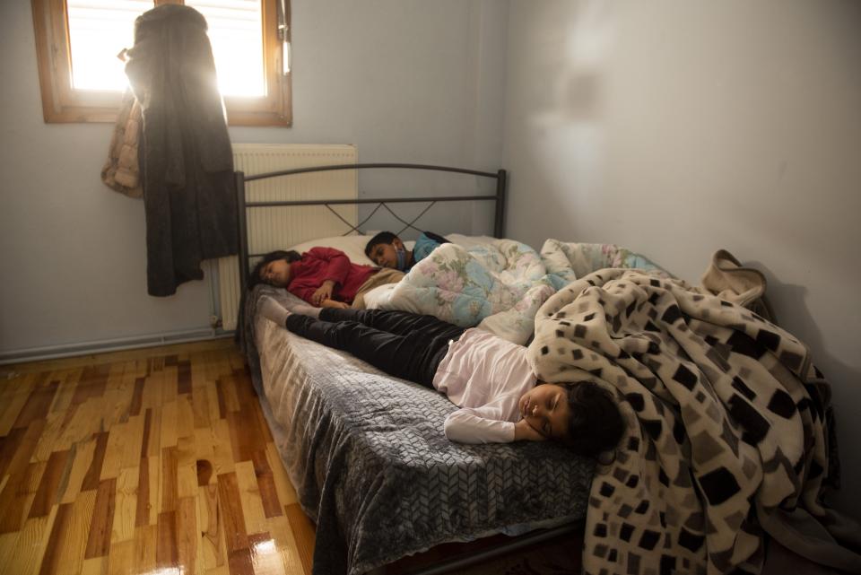 Layan, front, Bayan, back left and Hamsa sleep inside their apartment in the northern city of Thessaloniki, Greece, Saturday, May 1, 2021. Sundered in the deadly chaos of an air raid, a Syrian family of seven has been reunited, against the odds, three years later at a refugee shelter in Greece's second city of Thessaloniki. (AP Photo/Giannis Papanikos)