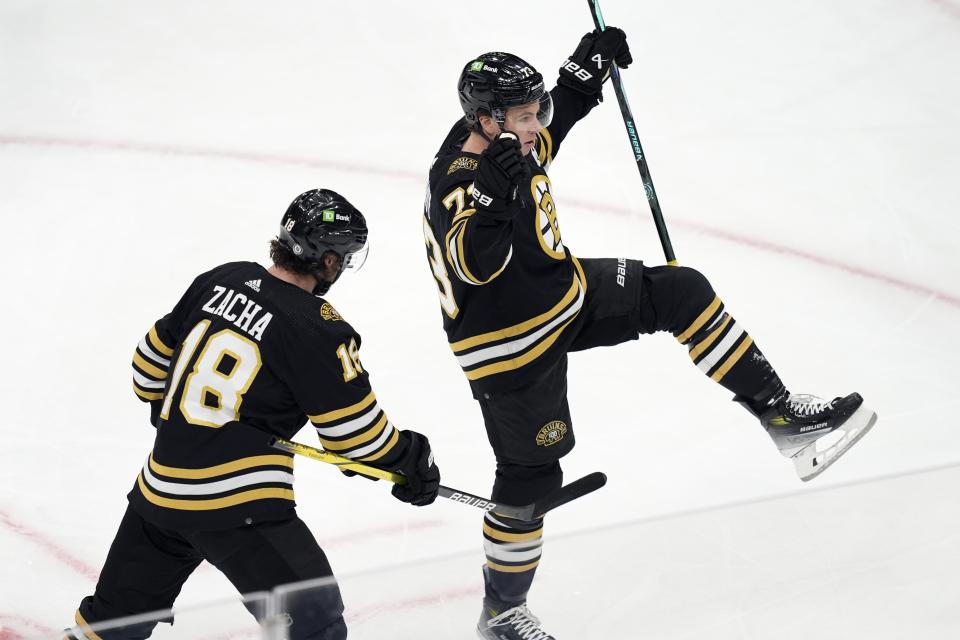 Boston Bruins' Charlie McAvoy (73) celebrates his goal with Pavel Zacha (18) during the first period of an NHL hockey game against the Florida Panthers, Saturday, April 6, 2024, in Boston. (AP Photo/Michael Dwyer)