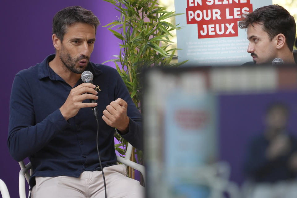 Tony Estanguet, head the organizing committee of the Paris 2024 Games, left, answers questions Tuesday, Sept. 26, 2023 in Saint-Denis, a northern suburb of Paris. Paris Olympics organizers and their partners organized a giant job fair meant to help filling about 16,000 vacancies in key sectors including catering, security, transport and cleaning. About 50 companies are recruiting to be able to welcome next year millions of spectators and 14,500 athletes. (AP Photo/Nicolas Garriga)