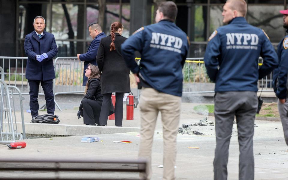 Emergency personnel respond at the scene where a person was covered in flames, outside the courthouse where former U.S. President Donald Trump's criminal hush money trial