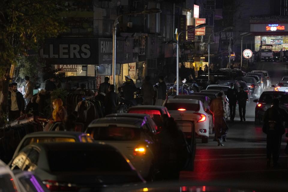 People visit a market, where some shopkeeper are using generators for electricity during a national-wide power breakdown, in Islamabad, Pakistan, Monday, Jan. 23, 2023. Much of Pakistan was left without power Monday as an energy-saving measure by the government backfired. The outage spread panic and raised questions about the cash-strapped government's handling of the country's economic crisis. (AP Photo/Anjum Naveed)