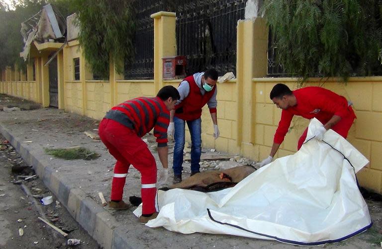 Syrian rescue workers remove a body following a string of air strikes on the Islamic State group's self-proclaimed capital Raqa, on November 25, 2014