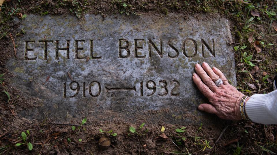 A relative of Ethel Benson touches Benson's headstone in the Stockley Center Cemetery in Georgetown, Delaware. Benson was sterilized in 1932 and died weeks later.