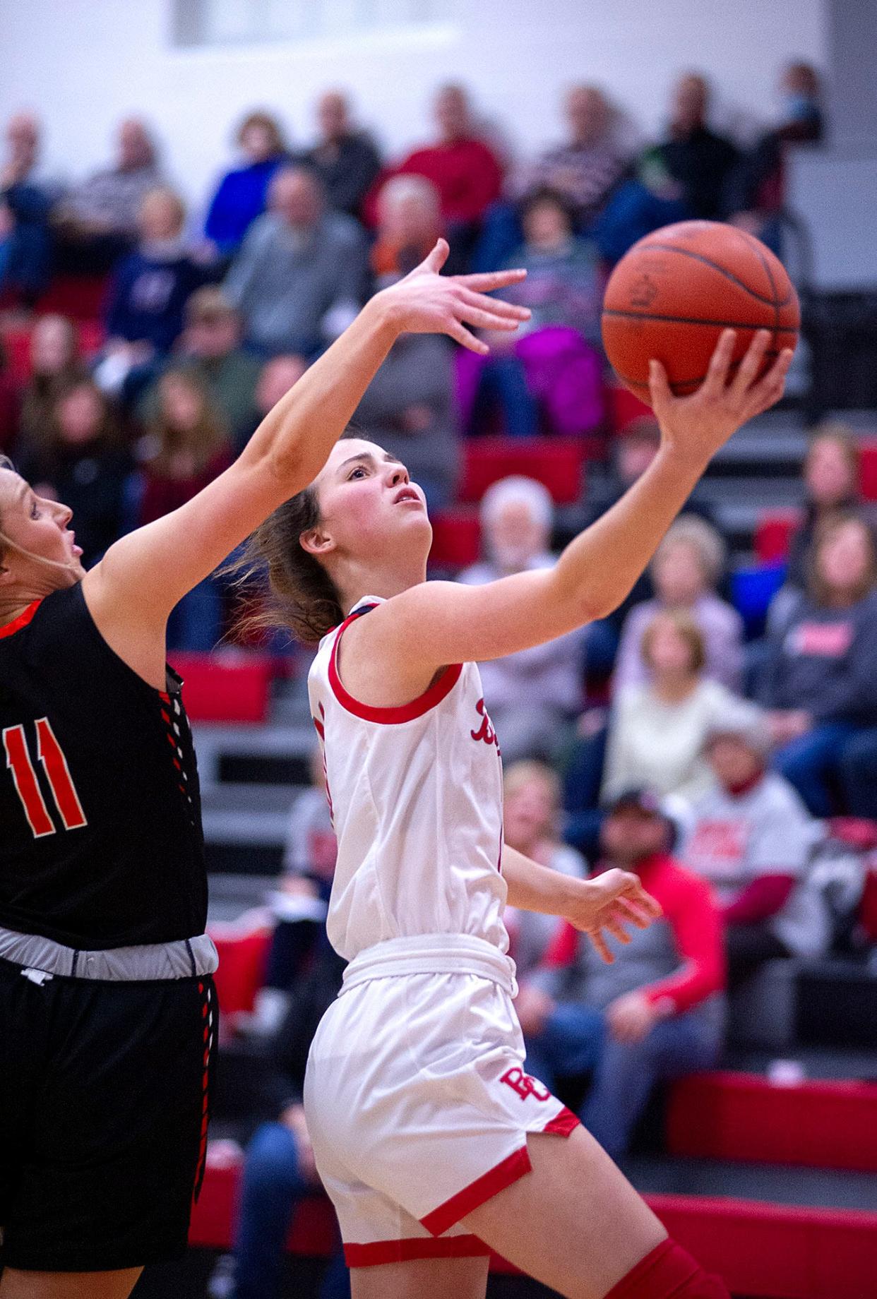 Buckeye Central's Kennedy Deppen lays the ball in ahead of Seneca East's Brooke Bordner.