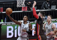 San Antonio Spurs guard Lonnie Walker IV, left, drives to the basket on Portland Trail Blazers center Jusuf Nurkic during the first half of an NBA basketball game in Portland, Ore., Saturday, May 8, 2021. (AP Photo/Steve Dykes)